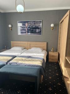 a bedroom with two beds and a picture of a car at Autopapa in Rustavi