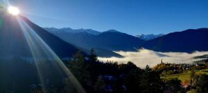 vista su una valle con il sole che splende sulle montagne di Alpenzauber Tilg a Imst