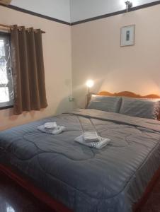 1 dormitorio con 1 cama grande y 2 toallas. en Bolaven trail guesthouse en Pakse