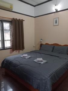 1 dormitorio con 1 cama con 2 toallas en Bolaven trail guesthouse en Pakse