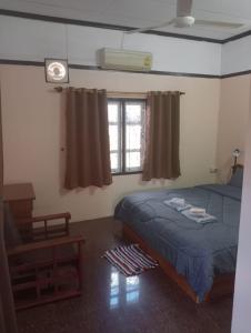 een slaapkamer met een bed, een tafel en een raam bij Bolaven trail guesthouse in Pakse