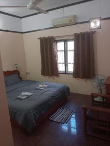 um quarto com uma cama e uma janela em Bolaven trail guesthouse em Pakse