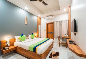a bedroom with a bed and a desk and a television at Treebo Lake City in Bhopal +32 photos