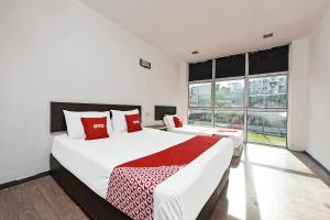 um quarto com 2 camas e uma grande janela em OYO 90892 L&E Hotel em Seremban