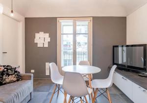 a living room with a table and chairs and a tv at Casa Accademia: unica e centrale in Turin
