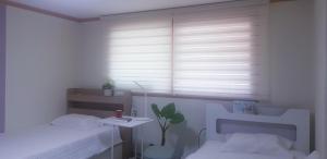 Habitación blanca con cama y ventana en Yire House, en Seúl