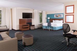 a hotel room with a bed and a couch at Fairfield Inn and Suites Atlanta Airport South/Sullivan Road in Atlanta