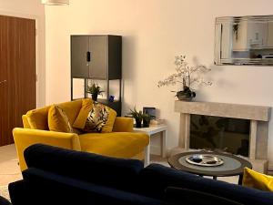 a living room with a yellow couch and a fireplace at City Centre Chester Waterways Apartment in Chester