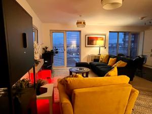 a living room with a black couch and a yellow chair at City Centre Chester Waterways Apartment in Chester