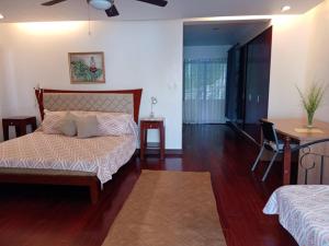 a bedroom with a bed and a table and a desk at Linden Beach Talikud in Santa Cruz
