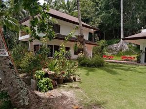 a house with a green yard with red benches at Linden Beach Talikud in Santa Cruz