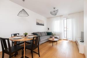a living room with a table and a couch at Orange Sipelga Balcony & Free Parking in Tallinn
