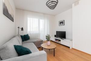 a living room with a couch and a tv at Orange Sipelga Balcony & Free Parking in Tallinn