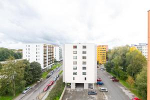 a white building on the side of a city street at Orange Sipelga Balcony & Free Parking in Tallinn