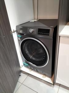 a washing machine in a cabinet in a kitchen at Lizzy's Exclusive Studio in Pretoria
