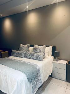 a bedroom with a large bed with a black wall at Lizzy's Exclusive Studio in Pretoria