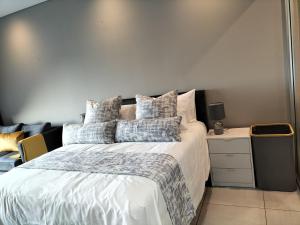 a bedroom with a large white bed with pillows at Lizzy's Exclusive Studio in Pretoria