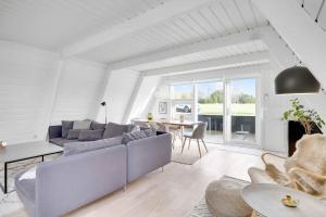 een woonkamer met een bank en een tafel bij Summer House At Himmerland Golf Resort in Farsø