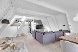 a living room with a couch and a table at Summer House At Himmerland Golf Resort in Farsø