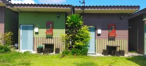 宗通縣的住宿－Bansuan Inthanon Resort，一座色彩缤纷的房子,前面有一棵棕榈树