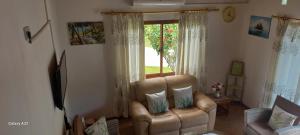 a living room with a couch and a window at Loversnest Self Catering in Anse aux Pins
