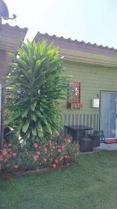 una palmera frente a una casa con flores en Bansuan Inthanon Resort, en Chom Thong