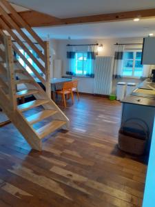 a living room with a wooden staircase and a kitchen at Ferienhaus Wietsche in Burscheid