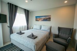 a small bedroom with a bed and a chair at Mantra Beach Condominium Suite 2 - Mae Phim in Ban Tha Fat