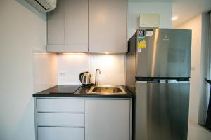 a kitchen with a stainless steel refrigerator and a sink at Mantra Beach Condominium Suite 2 - Mae Phim in Ban Tha Fat