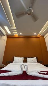 1 dormitorio con 1 cama con manta en forma de corazón en Green View Suites, en Gubbi