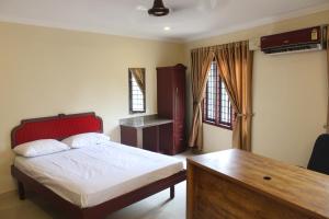 a bedroom with a bed and a desk in it at LILLY RESIDENCY by Chungath in Perumbavoor