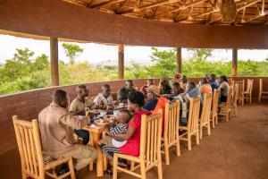 a group of people sitting at a table in a restaurant at Mara Safari Lodge Kidepo 