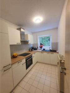 eine kleine Küche mit weißen Schränken und einem Fenster in der Unterkunft Dennis Apartment in Dresden