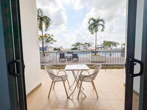 d'une table et de chaises sur un balcon avec vue sur l'océan. dans l'établissement Lovina 5-03 at Harbour Bay Residence(Ferry Terminal), à Batu Ampar