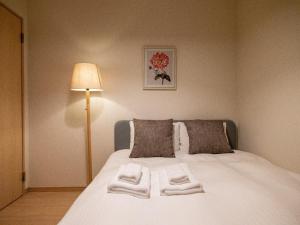 1 dormitorio con 1 cama con toallas en Sumiyoshi Marie - Vacation STAY 12160 en Osaka