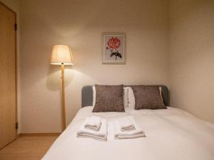 a bedroom with a bed with towels on it at Sumiyoshi Marie - Vacation STAY 12160 in Osaka