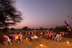 a group of tables and chairs in a field at night at Pafuri Camp in Makuleke Contract Park