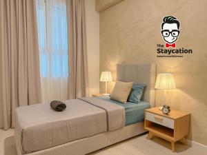 Staycation Homestay 31 Skyvilla Condominium near MJC في كوتشينغ: غرفة نوم مع سرير و ملصق على الحائط +37 صورة