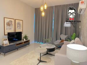 Staycation Homestay 31 Skyvilla Condominium near MJC في كوتشينغ: غرفة معيشة مع أريكة وتلفزيون