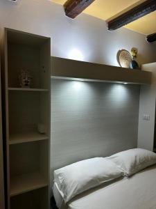 Schlafzimmer mit einem Kopfteil mit Regalen und einem Bett in der Unterkunft B&B La Bastia in Scilla