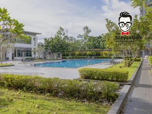 Staycation Homestay 31 Skyvilla Condominium near MJC في كوتشينغ: منتجع به حمام سباحة أمام مبنى