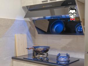 Staycation Homestay 31 Skyvilla Condominium near MJC في كوتشينغ: موقد المطبخ مع وعاء فوقه