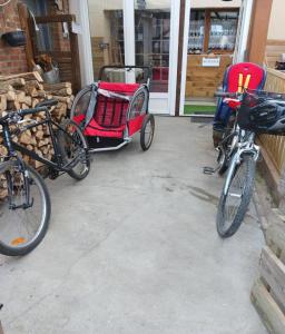 a couple of bikes and a red carriage at La Grangette d'Antan in Fenain