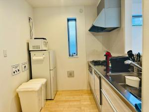 uma pequena cozinha com um frigorífico e um lavatório em MISTEL em Tóquio