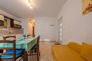- une salle à manger et une cuisine avec une table et un canapé dans l'établissement haus toni, à Ražanac