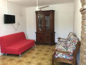 a living room with a red couch and a chair at Casa Roda in Castiglione del Lago