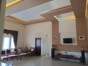 a living room with couches and a flat screen tv at Jomariz Homestay in Labuan Bajo +42 photos