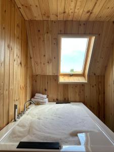 DragashにあるVilla deluxe n'Bjeshkëの窓付きの木製の部屋のバスタブ