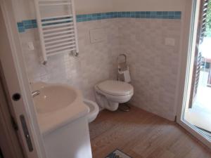 a white bathroom with a toilet and a sink at Bilocali e Mono al mare in Senigallia