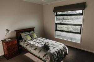 Schlafzimmer mit einem Bett und einem Fenster in der Unterkunft Long Island Retreat (close to river, with Wi-Fi) in Murray Bridge